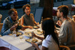 © bernardbodo - Friends enjoying dinner together at an outdoor restaurant