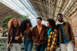 © bernardbodo - Happy multiracial friends walking together in a train station