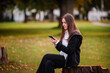© Иванна Емельянова - Young Woman Focused on Smartphone in a Park
