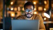 © LifeMedia - Focused young black man working late at a dimly lit office desk