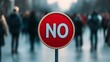 © Tanakrit - A red 'NO' sign stands in the foreground, blurred figures of people walking in the background, suggesting a message of rejection or prohibition.