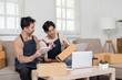 © wichayada - LGBT couple engaging in productive discussion about their online sales while packing orders at home