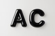 © Nyxoria - Black glossy letters AC on a neutral background, showcasing modern design and simplicity