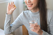 © KMPZZZ - Dietary supplement, asian young woman, girl hand holding fish oil pills, drugs medical, take or eat vitamin for treatment skin, hair and nail strengthen with glass of water at home. Healthcare concept