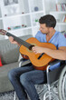 © auremar - man sitting on wheelchair playing guitar