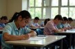 © Sergey - Focused students taking a test in classroom with bright windows