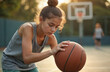 © Vadym - Young fit girl holds basketball on court in sunlight. Healthy teen focused on ball playing game. Active lifestyle. Sport workout routine. Afternoon basket training, doing exercise for healthy life.