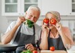 © Aliaksandr Barouski - Happy elderly couple cooking together, holding tomatoes and herbs in the kitchen