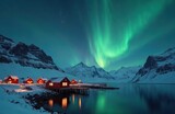 Winter landscape with aurora borealis over Lofoten Islands, Norway at night. Green northern lights above mountains and red houses in the evening, reflecting in water. Polar night scene.