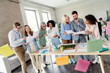© deagreez - Diverse group of professionals collaborating on ideas and documents around a table in a modern office setting