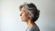 © Vadym - Side profile of middle aged woman on white background in studio. Mature lady with grey hair. Elegant attractive person with natural beauty. Elderly retired model. Copy space blank for text.