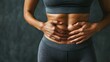 © elena - Woman, hands and fitness with stomach for diet, health and wellness on a gray studio background. Closeup, person or frame with abdomen for gut digestion, weight loss or body transformation by space