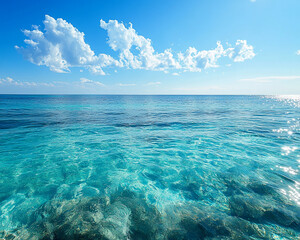 Fototapete - Clear turquoise ocean water with visible seabed, under a blue sky with fluffy white clouds, evokes serenity, peace, and summer vacation