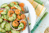 Cucumber carrot salad with sesame seeds in a plate with fork. Top view. Close-up.
