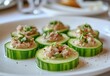 © ANUAR - Fresh Cucumber Slices Topped with Savory Tuna and Herbs on a White Plate for Gourmet Dining Experience