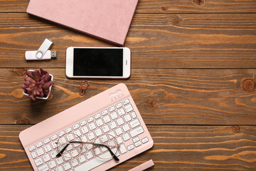 Wall Mural - computer keyboard, notebook and phone on wooden background