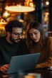 © DesignDepot - A man and woman attentively engage with a laptop, seated in a warm ambient setting. Their expressions convey concentration, suggesting collaboration or analysis. An intimate, focused atmosphere