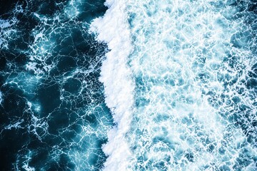 Poster - Aerial view of ocean waves in vivid blue tones with intricate white foam patterns on a dynamic background.