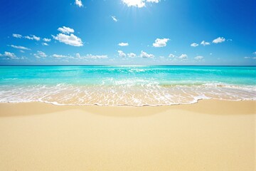 Poster - Scenic sandy beach with turquoise ocean waves under bright blue sky with clouds.