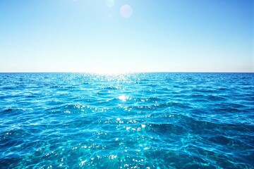 Poster - Bright ocean water with sunlight reflections under a clear blue sky.