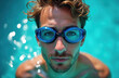© miss irine - Close-up portrait of swimmer in blue goggles in pool. Man swims, enjoying water sport activity. Healthy athletic lifestyle. Summer recreation. Azure clear water. Pro swimmer shows performance in