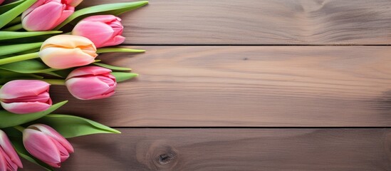 Aufkleber - Pink and yellow tulips arranged on a textured wooden table with ample space on the right for text or additional design elements