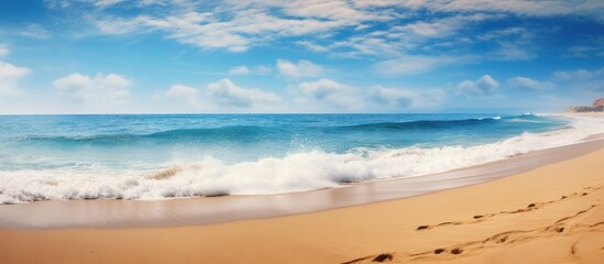 Aufkleber - Serene beach scene featuring golden sand and gentle waves under a bright blue sky with fluffy clouds providing ample copy space on the shore