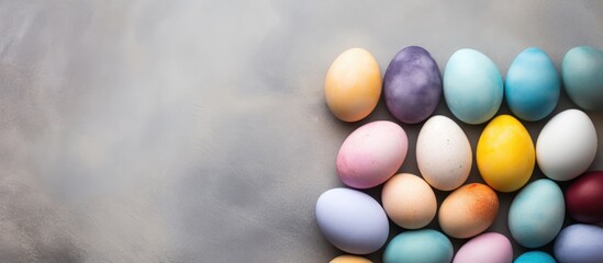 Poster - Colorful pastel Easter eggs in various hues arranged in a semi-circle on a textured stone background with ample copy space on the right side