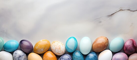 Poster - Colorful pastel Easter eggs arranged in a row on a light grey stone background with ample copy space above for text display.