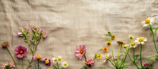 Aufkleber - Summer floral arrangement featuring pink, white, and yellow flowers arranged along the bottom of a beige linen background with ample copy space.