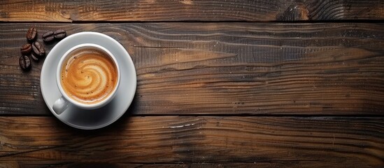 Poster - Top view of a white coffee cup with swirling pattern centered on a rustic wooden table with scattered coffee beans on the left and copy space on the right