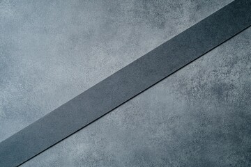 Poster - Diagonal Striped Texture: A close-up of a textured gray surface, bisected diagonally by a darker strip, forming a captivating abstract pattern