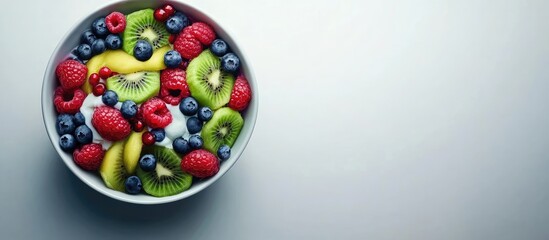 Poster - Fresh fruit yogurt bowl featuring vibrant kiwi slices, strawberries, blueberries, and raspberries in a round white bowl against a soft blue background.