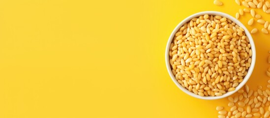 Aufkleber - Top view of yellow puffed wheat cereal in a white bowl on bright yellow background with scattered grains and ample copy space on the right