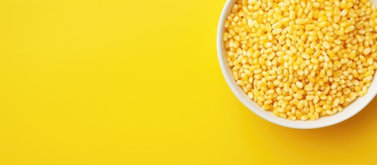 Poster - Close-up view of white bowl filled with honey air rice puffed wheat cereal on vibrant yellow background with ample copy space on the left side