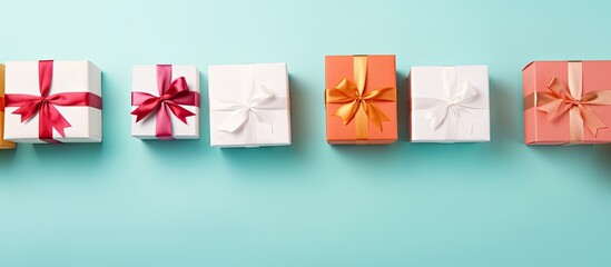 Poster - Colorful arrangement of white gift boxes with ribbons on a turquoise background, creating a festive and vibrant atmosphere with ample copy space.