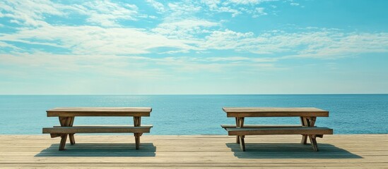 Aufkleber - Serene ocean view from vacant wooden tables on a boardwalk with turquoise waters and a clear blue sky enhancing the tranquil atmosphere.