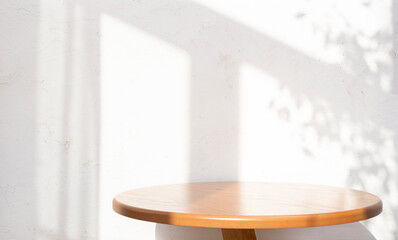 Wall Mural - empty round oak table on abstract texture white wall background with window dappled sunlight shadows