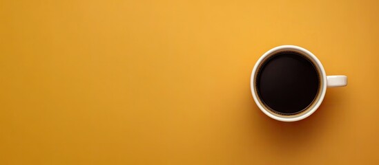 Poster - Top view of a brown coffee cup filled with black coffee centered on a warm yellow background with ample copy space for text and design elements