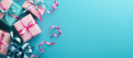 Poster - Festive flat lay with pink and blue ribboned gift boxes arranged on a vibrant aqua blue background featuring swirling ribbons and open space.