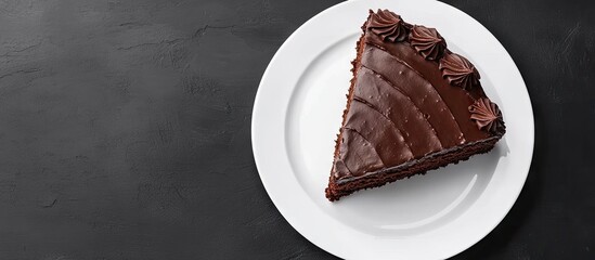 Poster - Chocolate cake slice on a white plate viewed from above with rich dark brown frosting and decorative swirls arranged symmetrically on top.