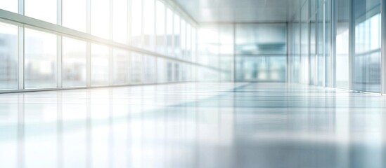 Poster - Bright spacious hallway with large glass windows, reflecting sunlight on a glossy floor, creating a modern and professional atmosphere.