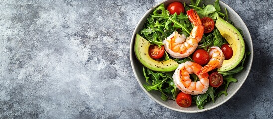 Poster - Healthy Shrimp Avocado Salad with Arugula and Cherry Tomatoes on a gray stone background featuring vibrant greens and reds in a bowl top view
