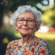 © romanets_v - Elderly caucasian woman smiling outdoors in floral dress and glasses