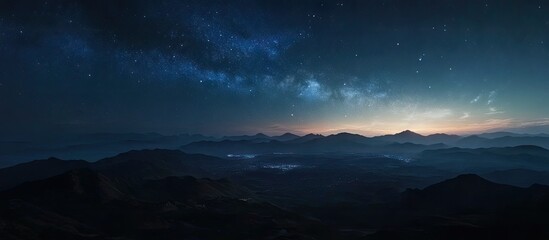 Wall Mural - Majestic mountain landscape at night with a vibrant Milky Way stretching across a deep blue sky, illuminated by distant stars and soft horizon glow