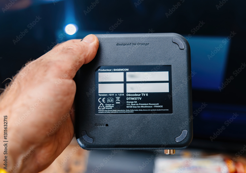 Paris, France - Feb 17, 2025: A person holds an Orange TV Decoder TV 6 ...