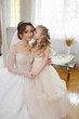 © Vasil - A bride and her daughter are posing for a picture. The bride is wearing a white dress and the daughter is wearing a white dress as well. Scene is happy and joyful