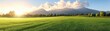 © nattapon - A picturesque landscape featuring lush green fields, majestic mountains, and a stunning sunset, ideal for nature, agriculture, or wellness themes in marketing and advertising,