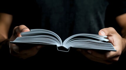Poster - Female hands holding open book with white pages against dark background, dramatic lighting creates atmospheric mood for reading, education and literature concepts.