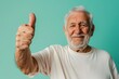 © Markus Schröder - Portrait of a content man in his 80s showing a thumb up isolated on soft teal background